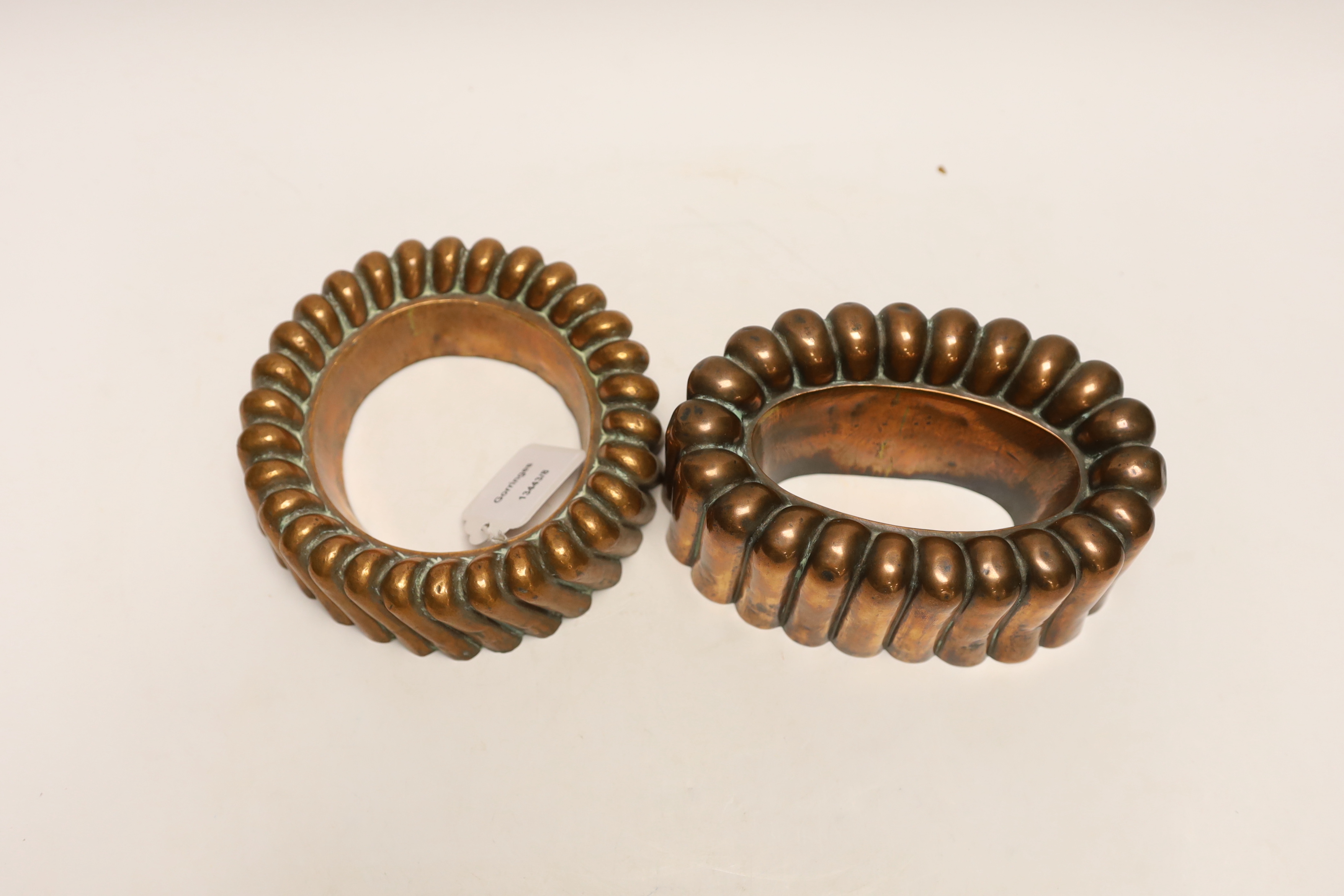 Two Victorian copper jelly moulds, the ring shaped example stamped Baileys hotel and the overall example stamped 64, largest 17cm wide